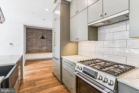 a kitchen with granite countertop a stove and a wooden cabinets