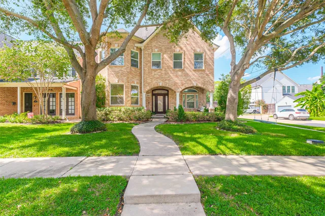a front view of a house with a garden and yard