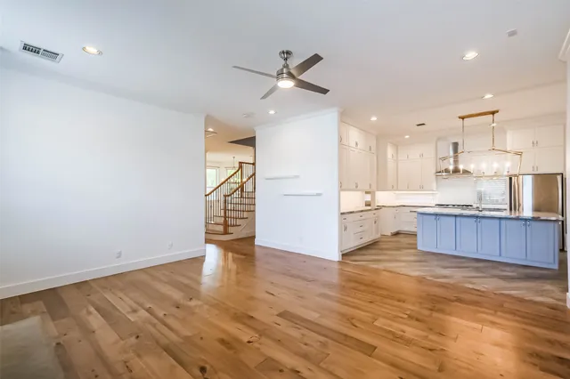 a kitchen with kitchen island a stove a sink and wooden floor