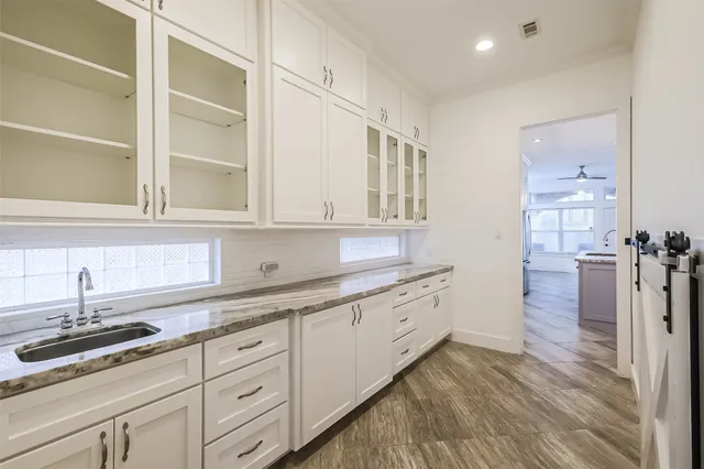 a view of a room with wooden floor chandelier and windows