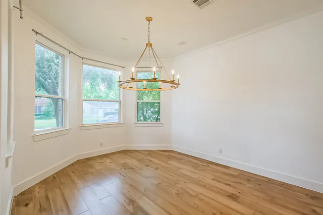 a kitchen with kitchen island granite countertop a stove a sink and white cabinets