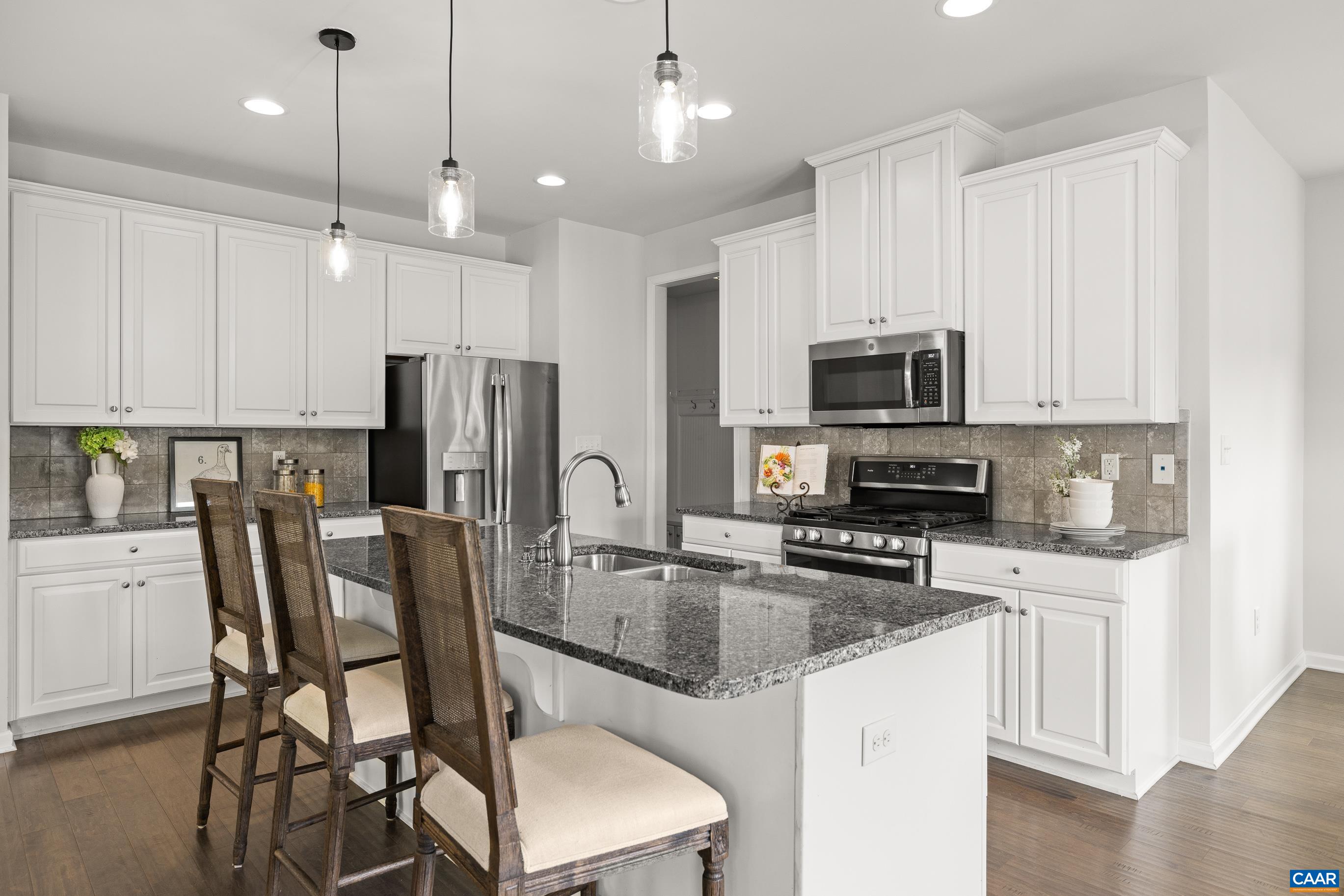1622 Fowler Ridge Court Charlottesville, VA 22901 - Photo 32 of 75 a kitchen with stainless steel appliances granite countertop a refrigerator a stove a sink a dining table and chairs with wooden floor