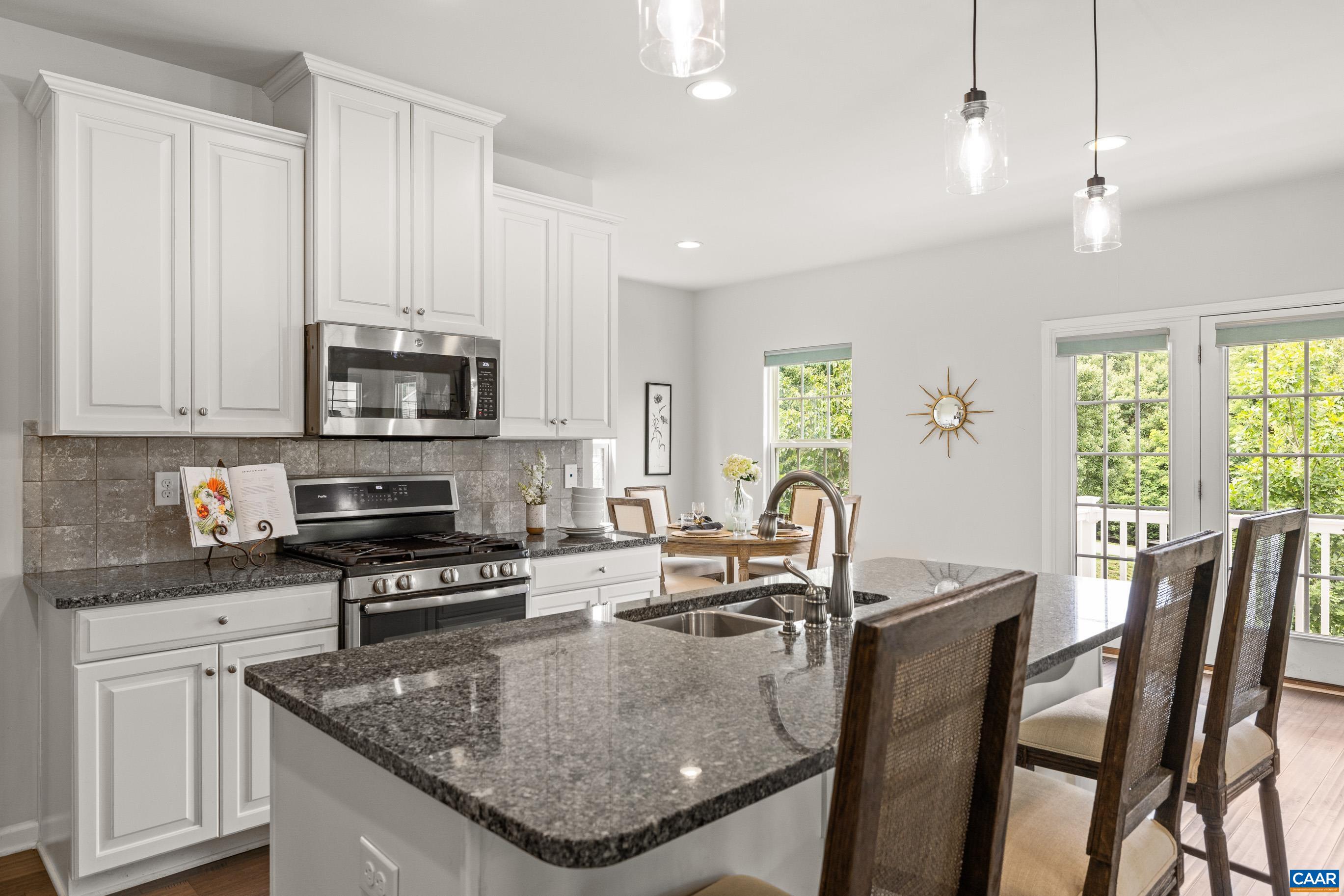 1622 Fowler Ridge Court Charlottesville, VA 22901 - Photo 35 of 75 a kitchen with stainless steel appliances granite countertop a stove a sink a microwave a dining table and chairs