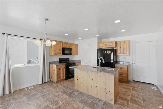 1218 Moonlight Drive Elk Ridge, UT 84651 - Photo 8 of 44 Kitchen with light stone counters, stone finish floors, black appliances, a center island with sink, and light wood finish cabinetry