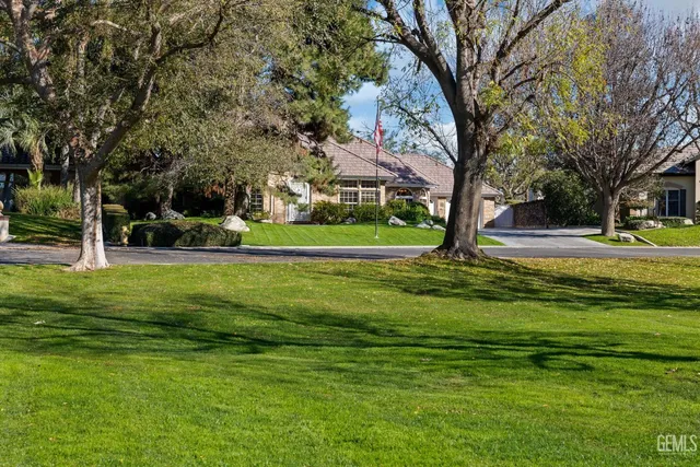 a view of an empty room with wooden floor and a fireplace