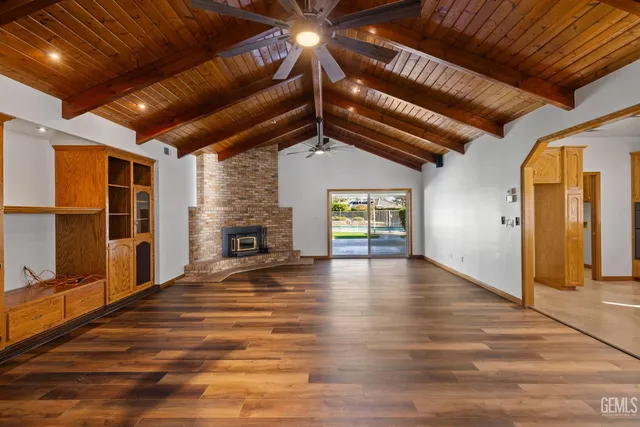 a view of a livingroom with wooden floor and a fireplace