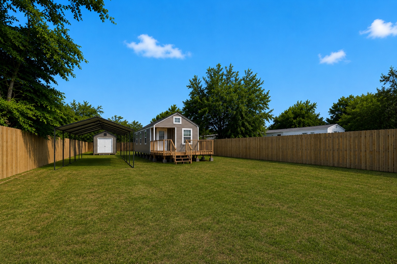 189 Watterson Road Bastrop, TX 78602 - Photo 4 of 22 A spacious, green yard features a charming small home with an elevated deck, an open-sided carport (in process of installation), and a separate storage shed.