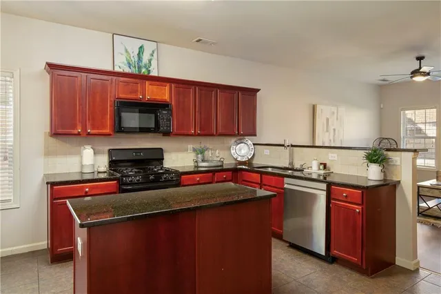 a kitchen with stainless steel appliances granite countertop a sink stove and microwave