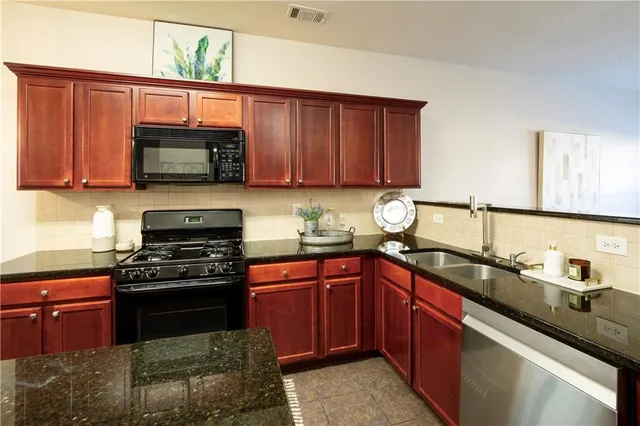 a kitchen with stainless steel appliances granite countertop a sink stove and microwave