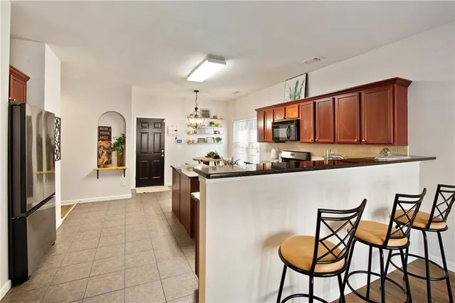 a kitchen with stainless steel appliances granite countertop a refrigerator and microwave
