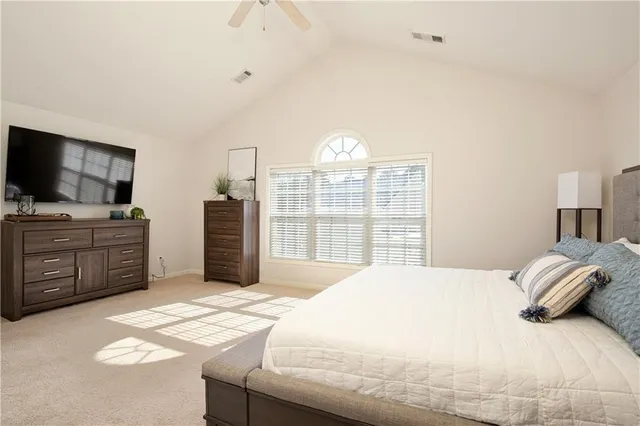 a bedroom with a bed and a flat tv screen on dresser