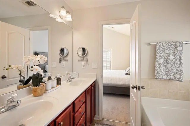 a en suite bathroom with a double vanity sink and a mirror