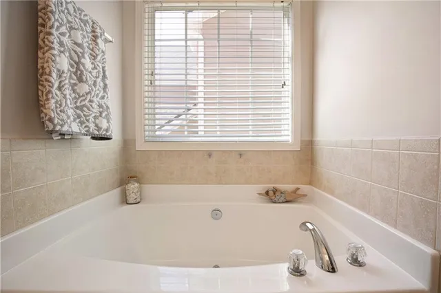 a white bath tub sitting in a bathroom next to a window