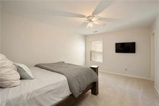 a bedroom with a bed tv and a window