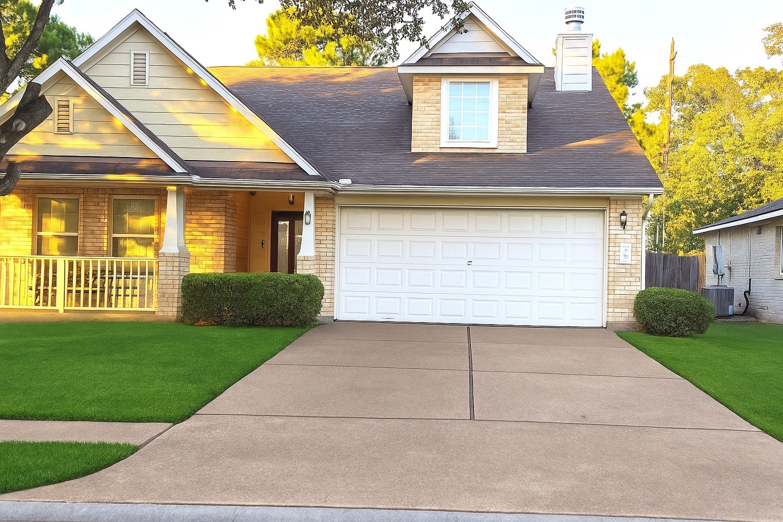 a view of a white house with a small yard and a large tree