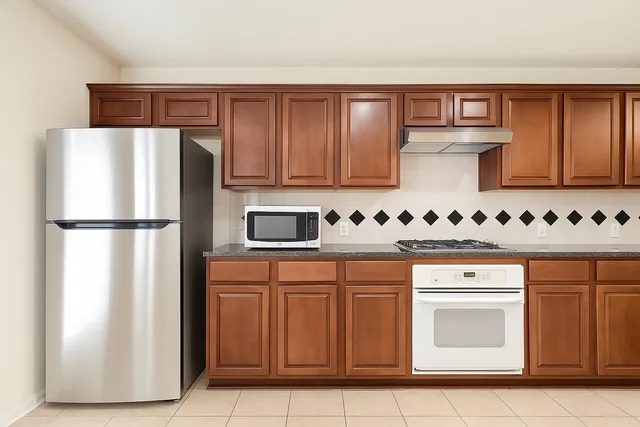 a kitchen with stainless steel appliances granite countertop a refrigerator sink and cabinets