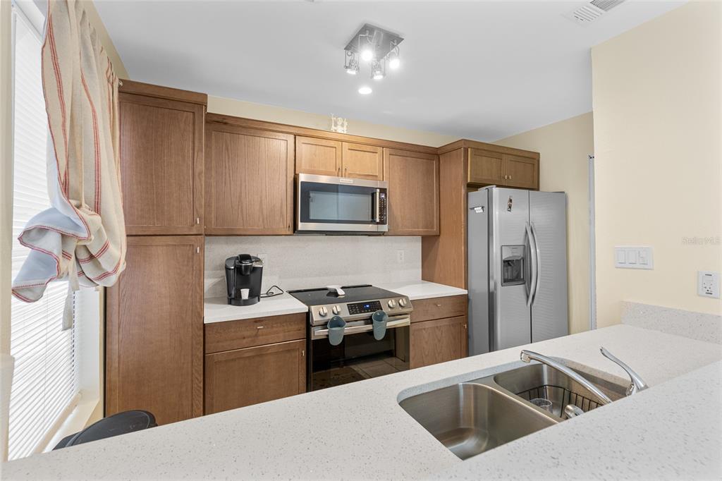 2004 Ludlow Lane, Unit 2803 Orlando, FL 32839 - Photo 11 of 31 a kitchen with a sink a stove a refrigerator cabinets and a dining table