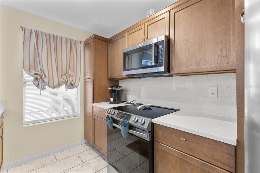 2004 Ludlow Lane, Unit 2803 Orlando, FL 32839 - Photo 13 of 31 a kitchen with stainless steel appliances granite countertop a stove and a microwave