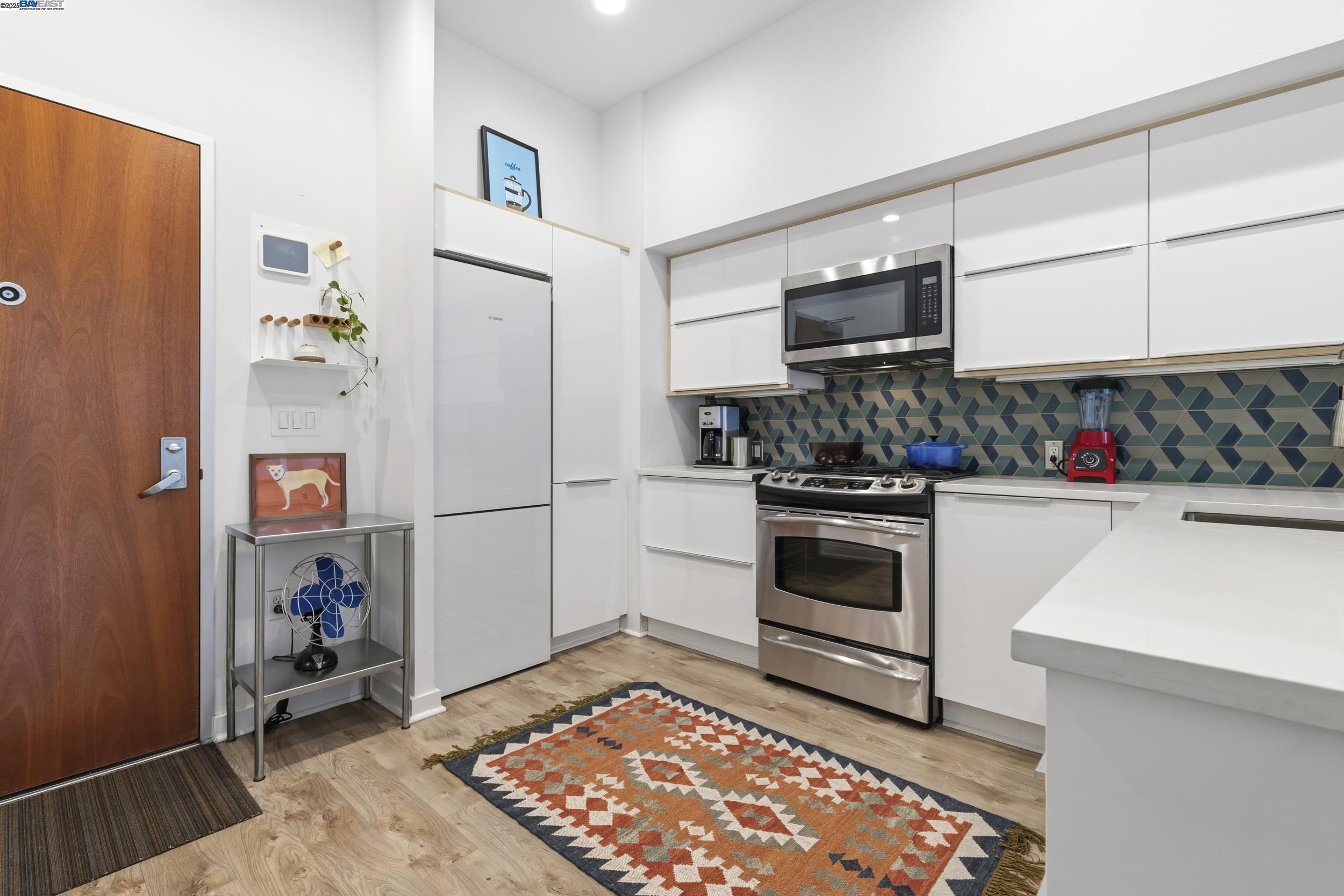630 Thomas L Berkley Way, Unit 403 Oakland, CA 94612 - Photo 16 of 29 a kitchen with a refrigerator and a stove top oven