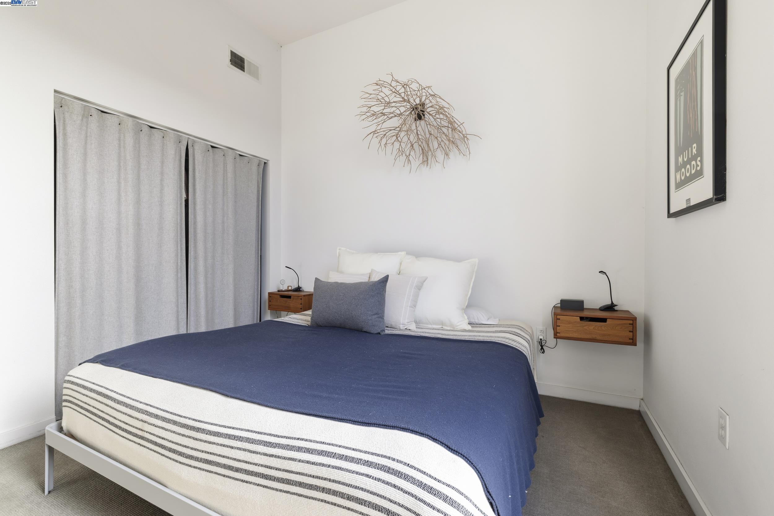 630 Thomas L Berkley Way, Unit 403 Oakland, CA 94612 - Photo 20 of 29 a bedroom with a bed and a chandelier