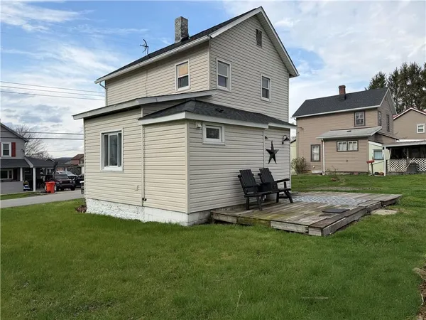 a view of backyard of house with outdoor seating and barbeque oven