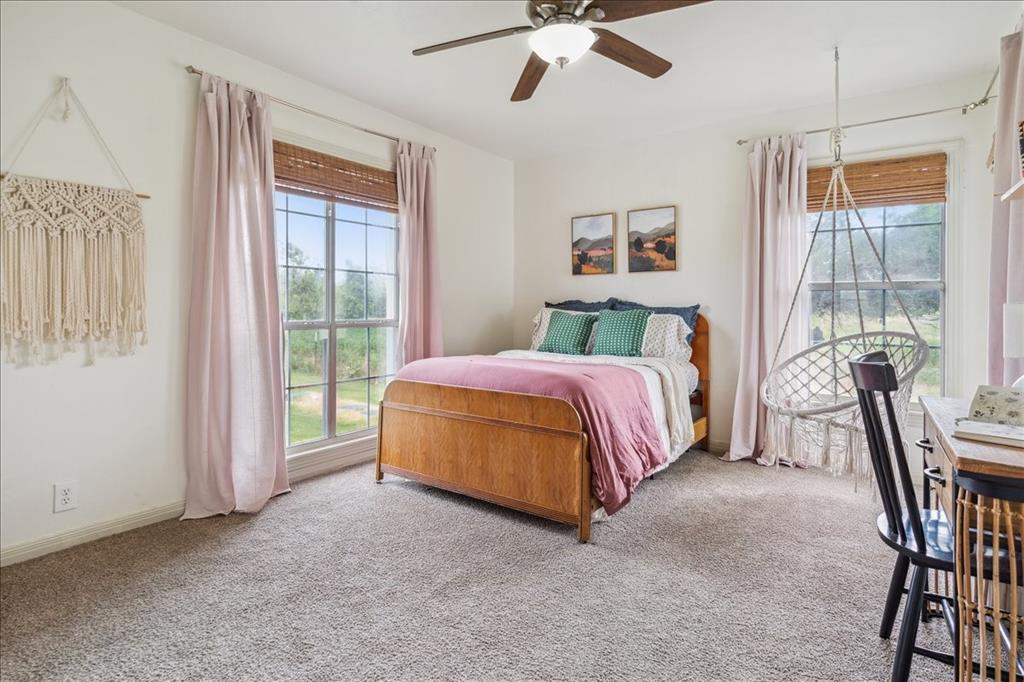 13347 Old China Spring Road China Spring, TX 76633 - Photo 23 of 38 a spacious bedroom with a bed a chandelier and a window