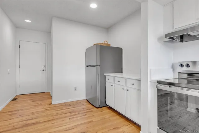 a kitchen with cabinets and wooden floor