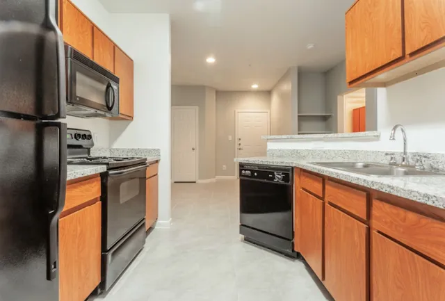 a kitchen with stainless steel appliances granite countertop a stove a sink and a microwave
