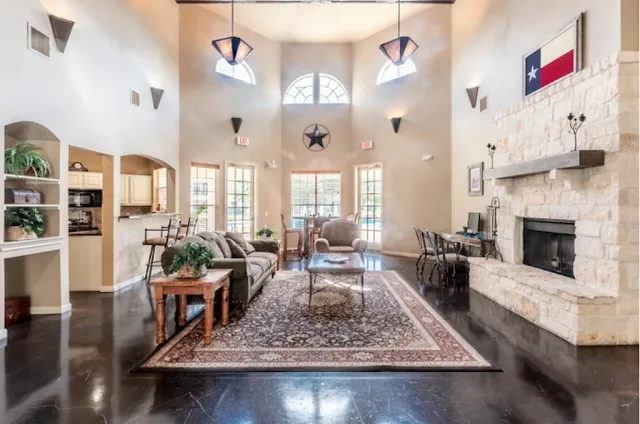 a living room with fireplace furniture and a rug