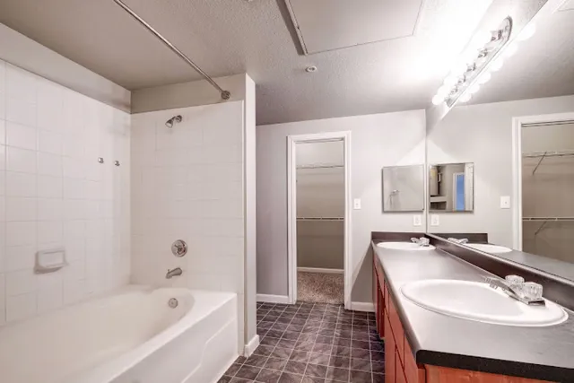 a bathroom with a bathtub a sink a mirror and a shower