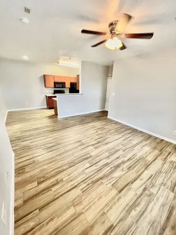 a view of empty room with wooden floor
