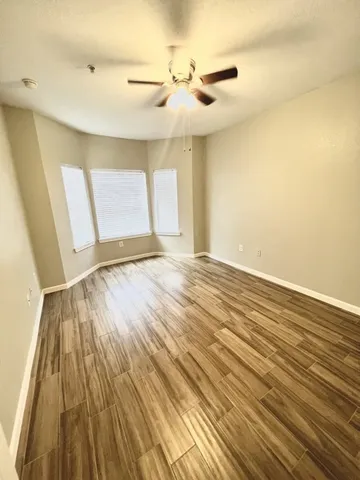 a view of an empty room with wooden floor