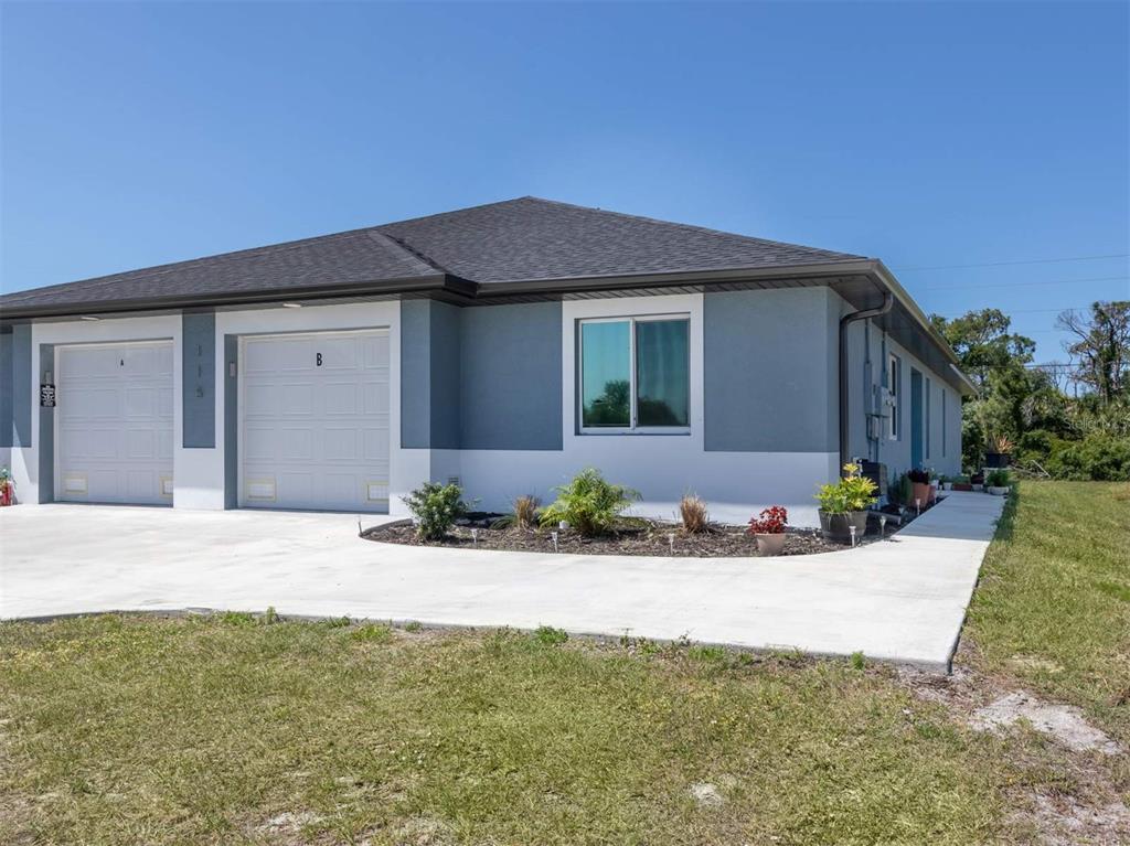 125 Boundary Boulevard, Unit 2 Rotonda West, FL 33947 - Photo 1 of 32 a front view of a house with a yard