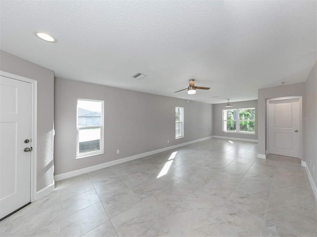 125 Boundary Boulevard, Unit 2 Rotonda West, FL 33947 - Photo 12 of 32 an empty room with windows and ceiling fan