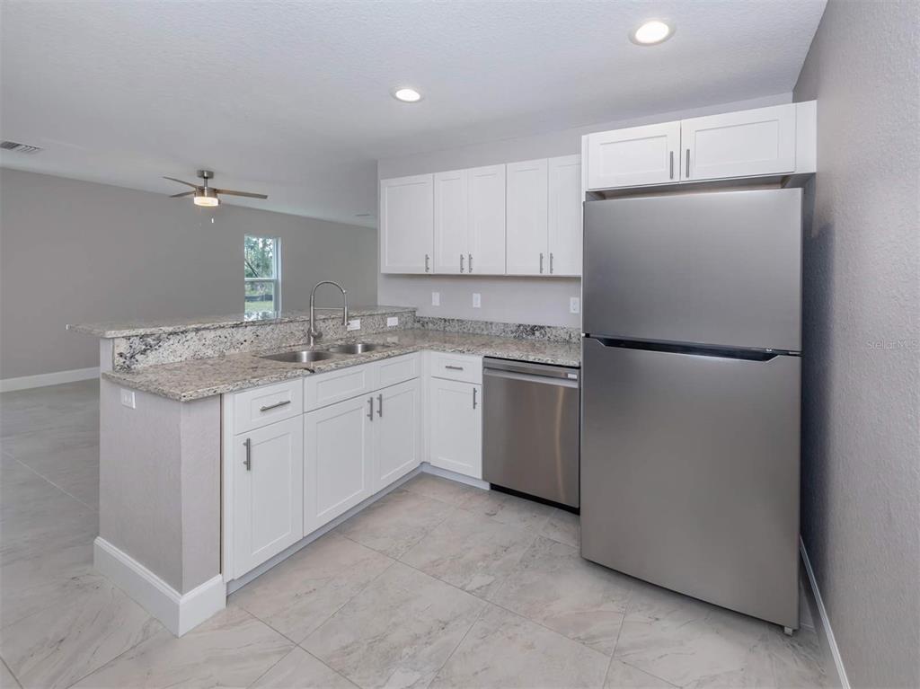 125 Boundary Boulevard, Unit 2 Rotonda West, FL 33947 - Photo 16 of 32 a kitchen with a sink a refrigerator and cabinets
