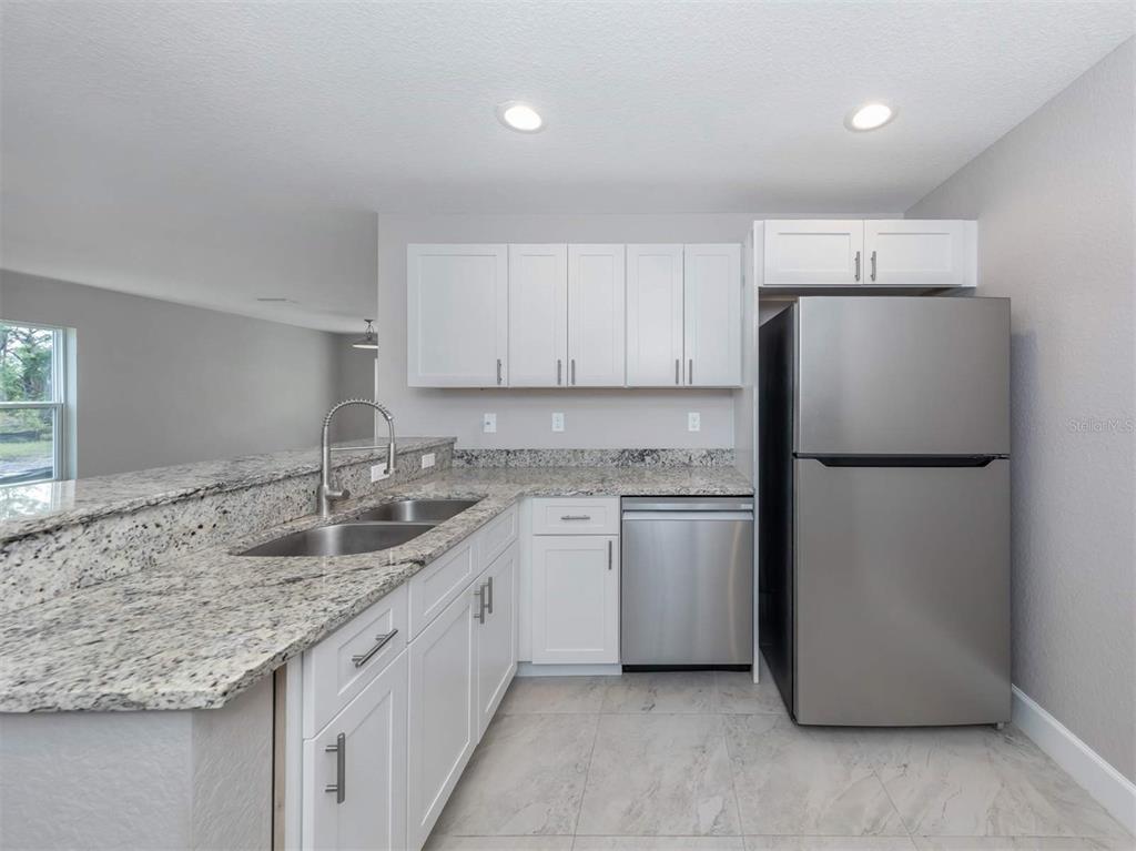125 Boundary Boulevard, Unit 2 Rotonda West, FL 33947 - Photo 17 of 32 a kitchen with a sink stove and refrigerator