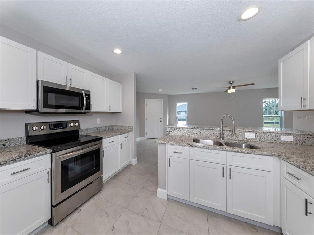 125 Boundary Boulevard, Unit 2 Rotonda West, FL 33947 - Photo 20 of 32 a kitchen with a sink stove and microwave