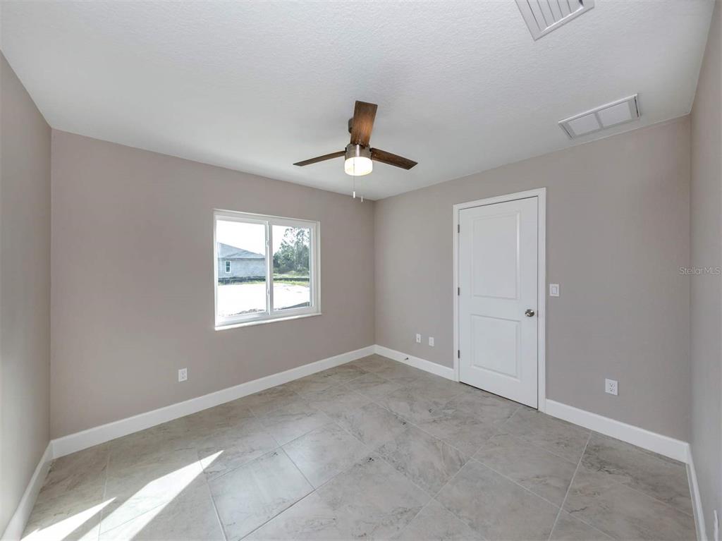 125 Boundary Boulevard, Unit 2 Rotonda West, FL 33947 - Photo 4 of 32 a room that has a window in it and a ceiling fan