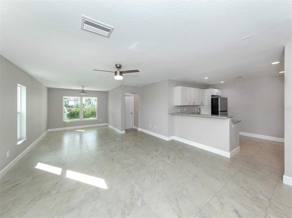 125 Boundary Boulevard, Unit 2 Rotonda West, FL 33947 - Photo 5 of 32 an empty room with windows and entrance door