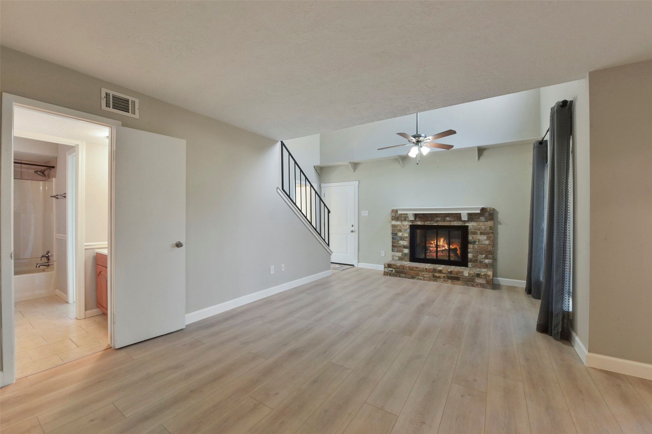 1941 Country Village Boulevard, Unit A Humble, TX 77338 - Photo 9 of 35 a view of an empty room with wooden floor fireplace and a window