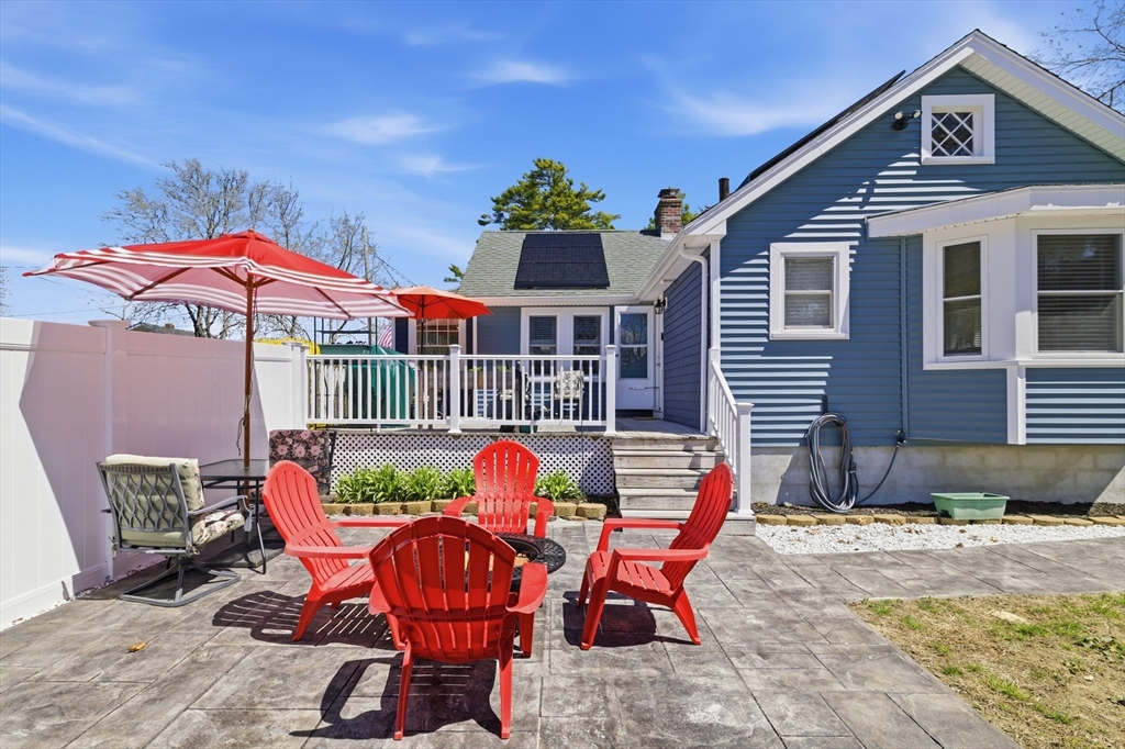 a patio with tables and chairs and a umbrella