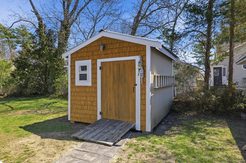 6 Birch Street Wareham, MA 02571 - Photo 16 of 25 a view of a small house with a small yard plants and large tree
