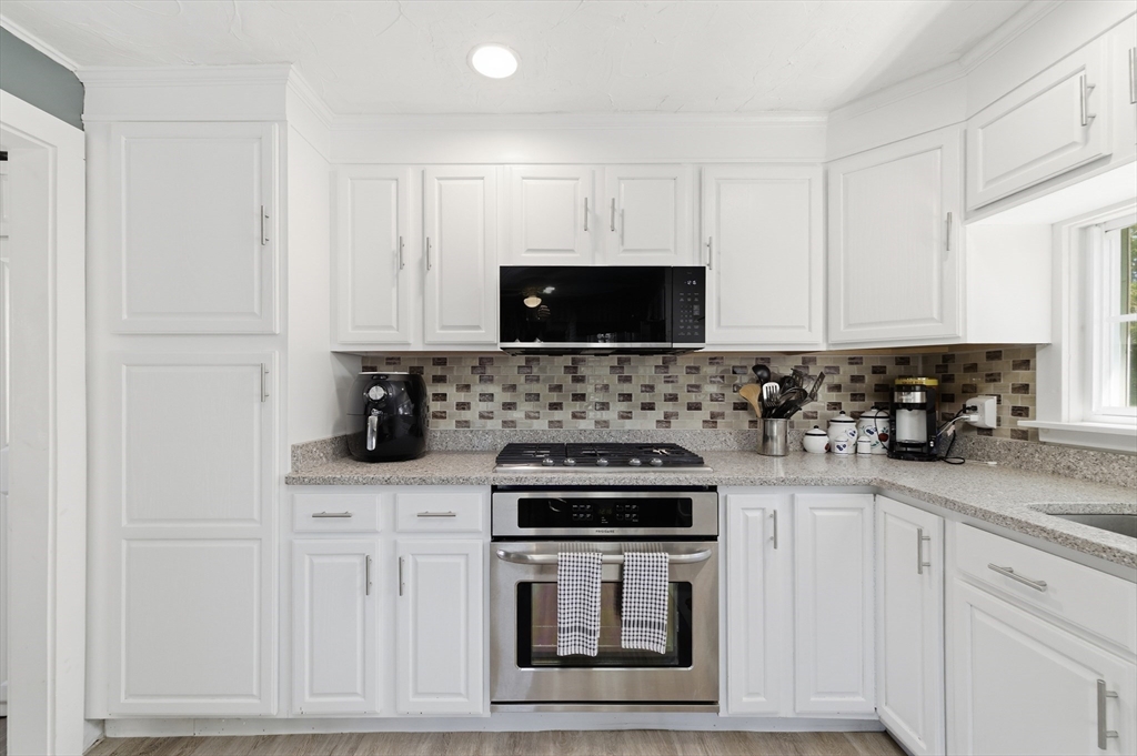 6 Birch Street Wareham, MA 02571 - Photo 4 of 25 a kitchen with stainless steel appliances granite countertop white cabinets stove a sink and dishwasher