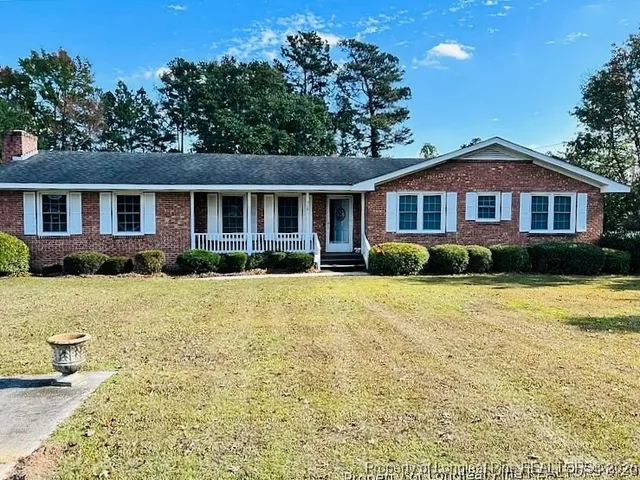 a front view of a house with a yard and outdoor seating