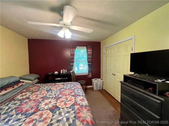a bedroom with a bed and a flat screen tv