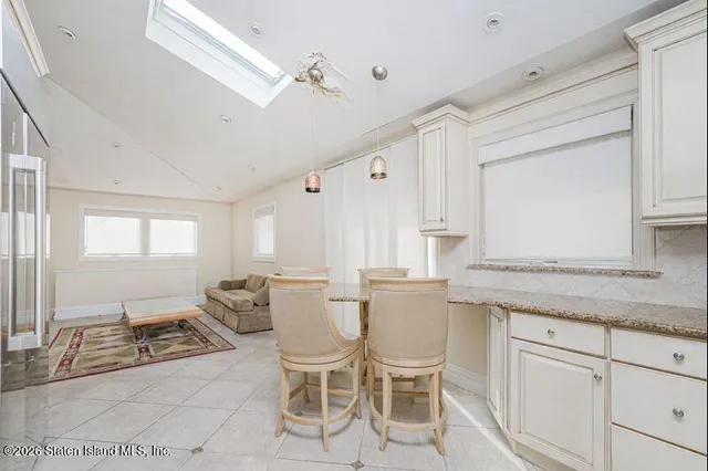 a kitchen with a dining table chairs cabinets and stainless steel appliances