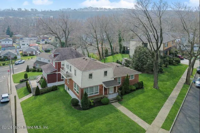 a aerial view of a house with a big yard and large trees