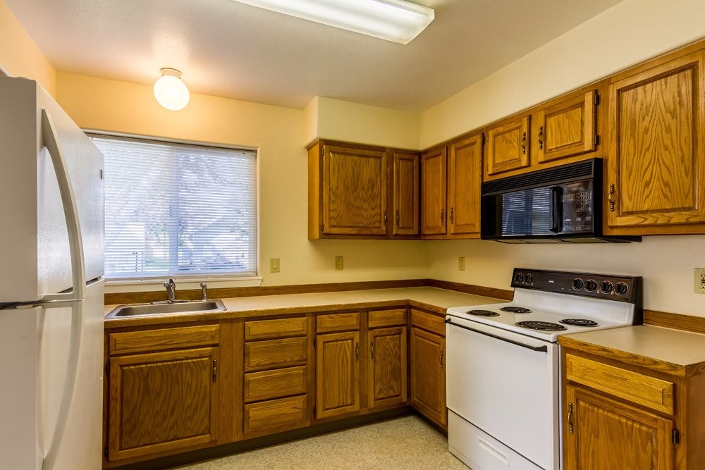 207 North Storie Street Wallowa, OR 97885 - Photo 7 of 9 a kitchen with stainless steel appliances granite countertop a stove a sink and a microwave