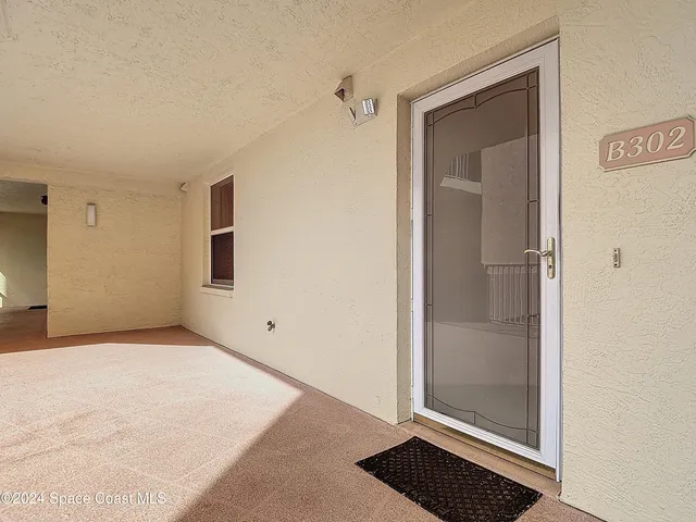 a view of a swimming pool with a lawn chairs potted plants and water view