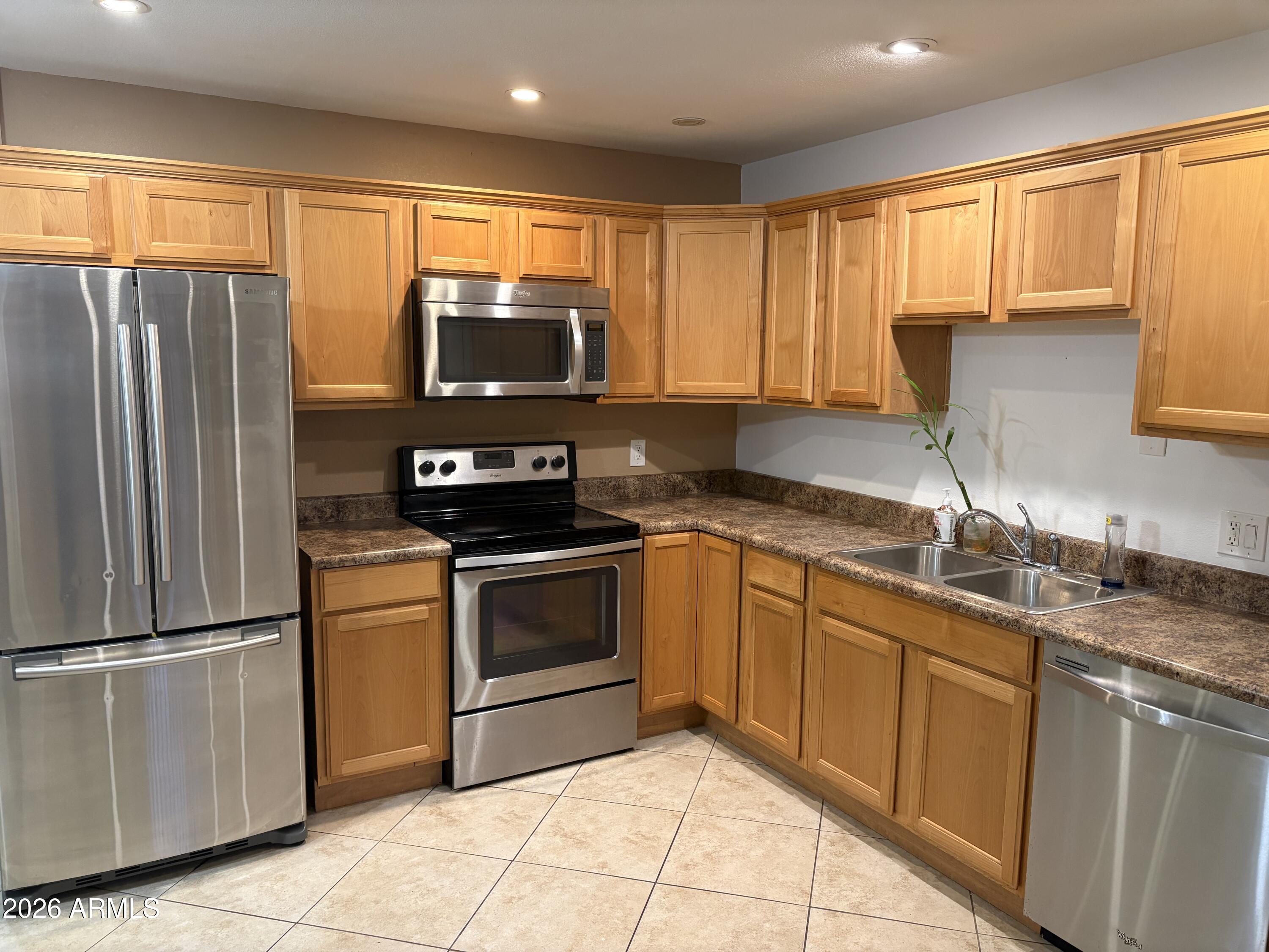 a kitchen with granite countertop a sink stainless steel appliances and cabinets